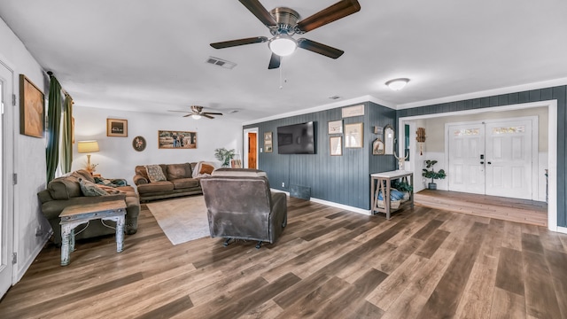 living room featuring hardwood / wood-style floors, ceiling fan, and crown molding