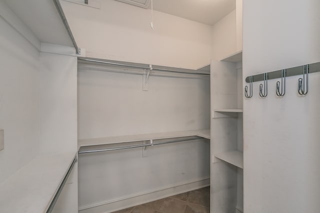 spacious closet featuring dark tile patterned flooring