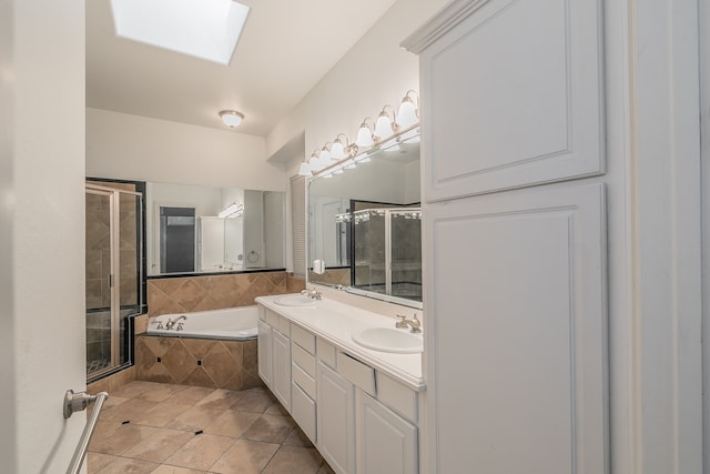 bathroom featuring tile patterned flooring, shower with separate bathtub, a skylight, and vanity