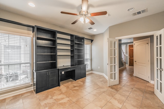 unfurnished office featuring ceiling fan, french doors, and a healthy amount of sunlight