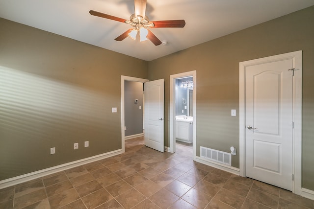 unfurnished bedroom featuring dark tile patterned flooring, ceiling fan, sink, and connected bathroom