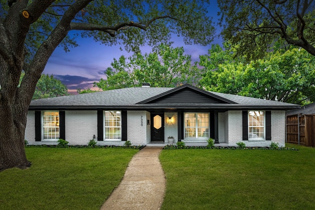 ranch-style home with a yard