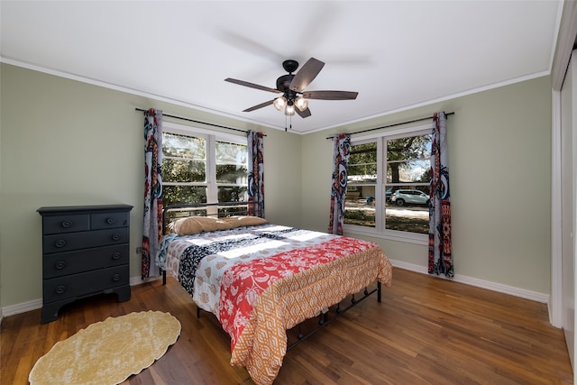 bedroom with dark wood-type flooring, ornamental molding, and ceiling fan