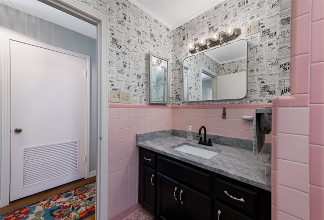 bathroom featuring vanity, wood-type flooring, crown molding, and tile walls