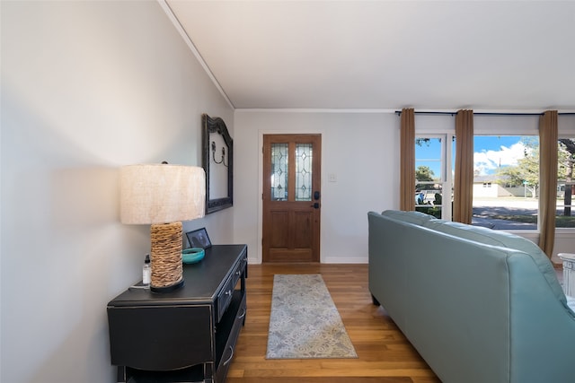 entryway with light hardwood / wood-style floors and ornamental molding