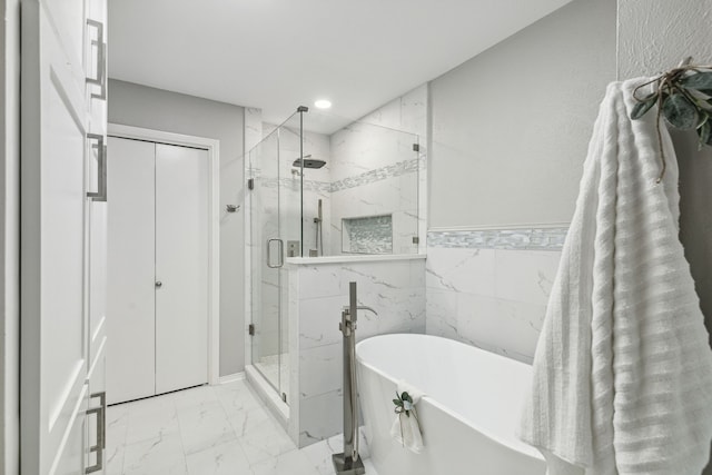 bathroom with tile walls and separate shower and tub