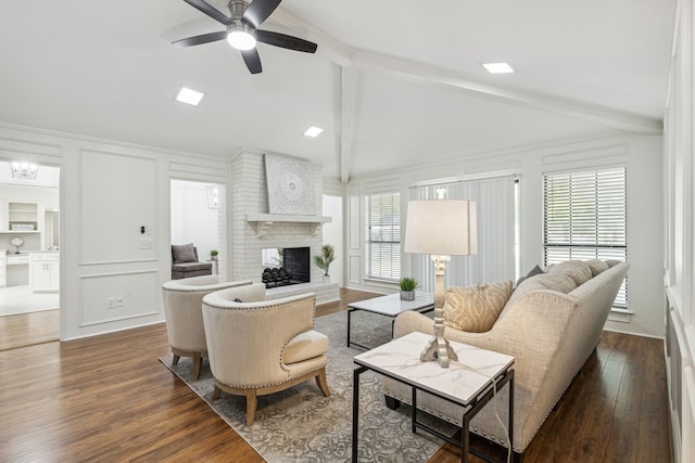 living room with dark hardwood / wood-style flooring, vaulted ceiling with beams, a fireplace, and ceiling fan