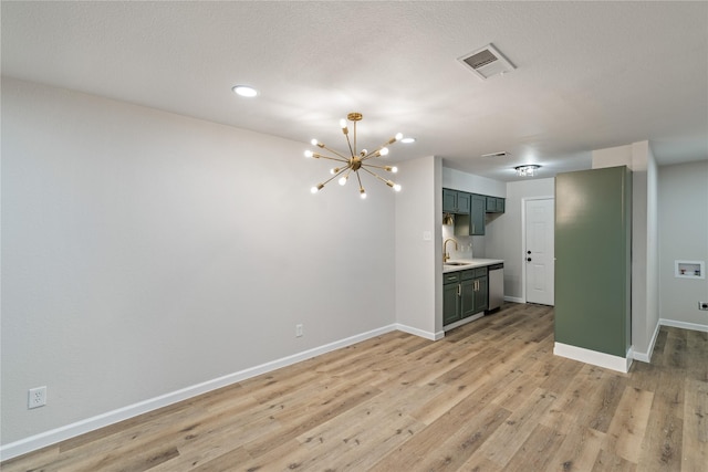 interior space featuring sink, an inviting chandelier, a textured ceiling, and light wood-type flooring