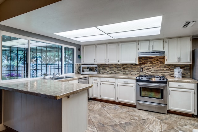 kitchen featuring kitchen peninsula, stainless steel range, and white cabinets