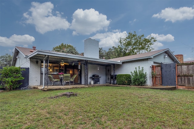 rear view of property featuring a lawn