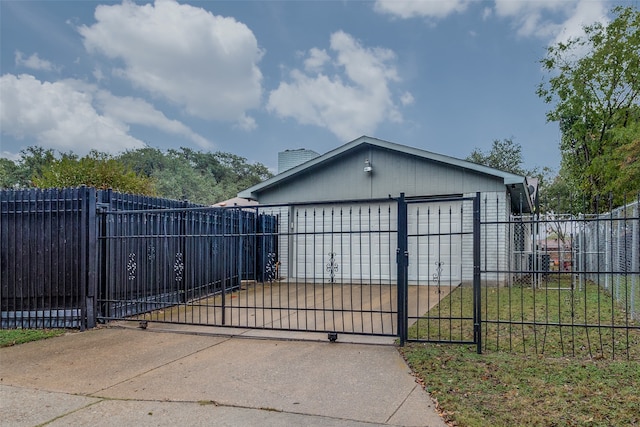 view of gate featuring a garage and a lawn