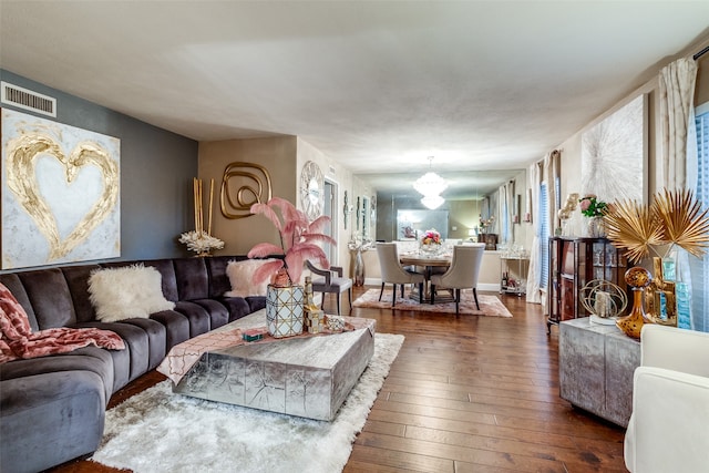 living room with a notable chandelier, dark hardwood / wood-style floors, and plenty of natural light