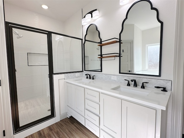 bathroom featuring hardwood / wood-style floors, vanity, and a shower with shower door