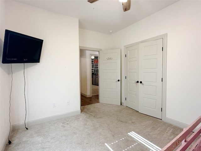 unfurnished bedroom with ceiling fan, a closet, and light colored carpet