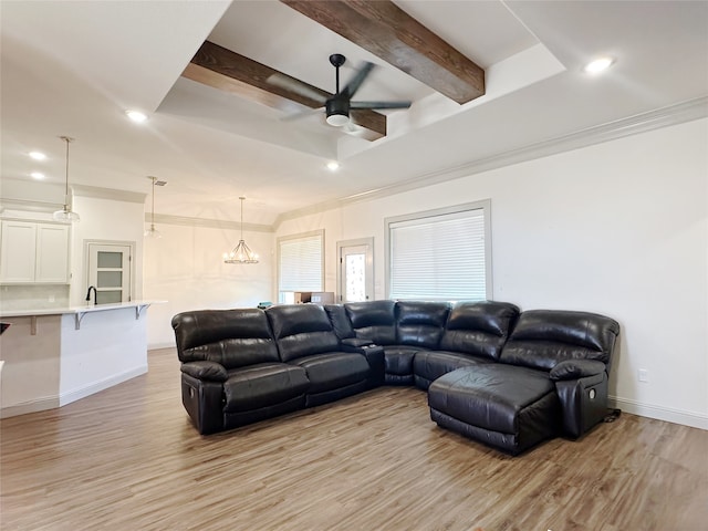 living room featuring ceiling fan with notable chandelier, beam ceiling, light wood-type flooring, and crown molding