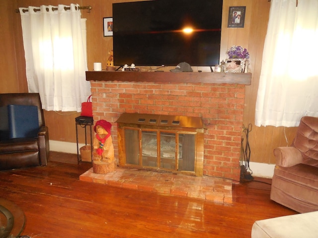 living room featuring wooden walls, hardwood / wood-style floors, and a fireplace