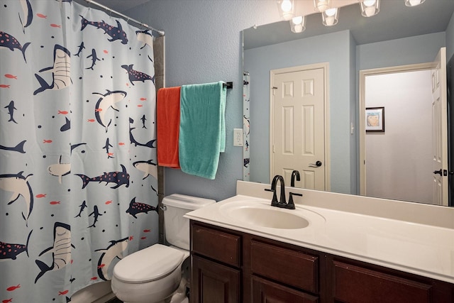 bathroom with toilet, vanity, and a shower with shower curtain