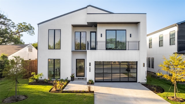 modern home featuring a front yard, a balcony, and a garage