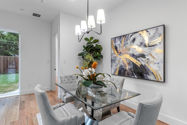 dining space featuring light hardwood / wood-style flooring and a chandelier