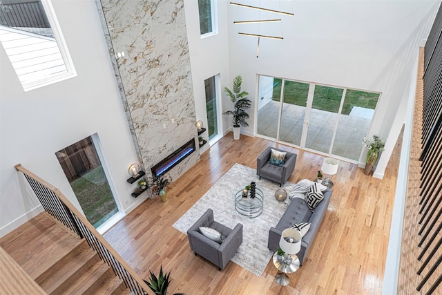 living room with hardwood / wood-style flooring, a healthy amount of sunlight, and a high ceiling