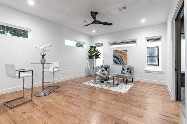 living area featuring light hardwood / wood-style flooring, a wealth of natural light, and ceiling fan