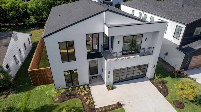 view of front of house with a front yard, a balcony, and a garage