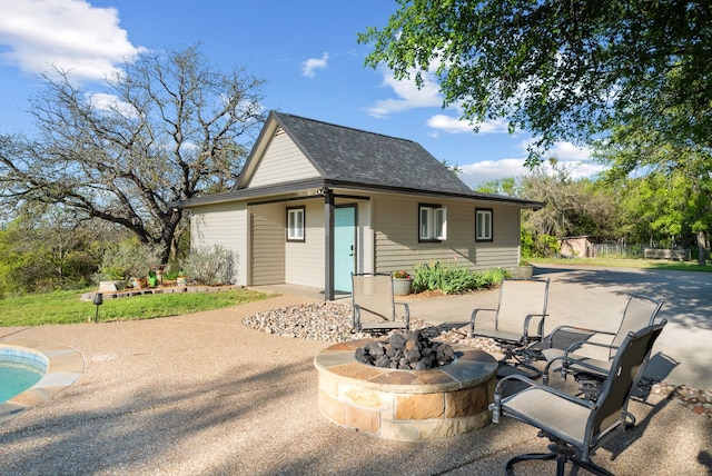 rear view of house featuring a fire pit and a patio area