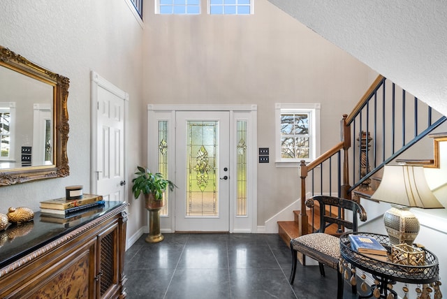 foyer entrance with a textured ceiling and a high ceiling