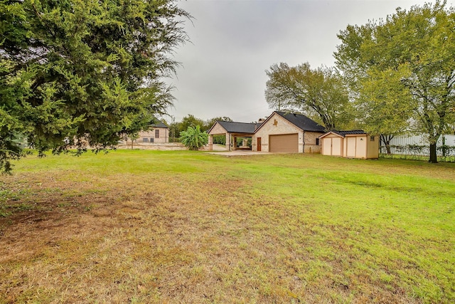 view of yard featuring a garage and a storage unit