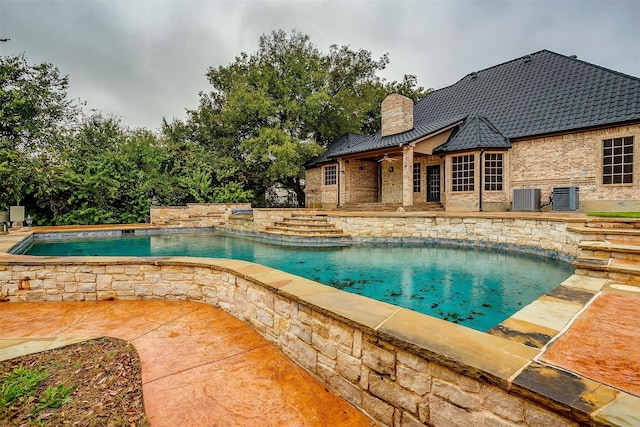 view of pool with central AC unit and a patio