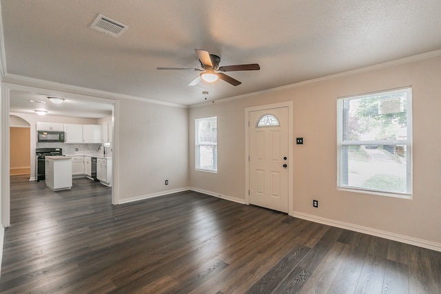 foyer with dark wood-type flooring, ceiling fan, and a healthy amount of sunlight