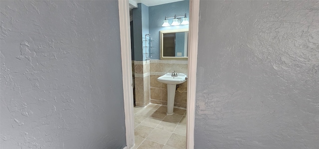 bathroom featuring tile walls, tile patterned flooring, and sink