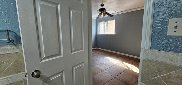 interior space featuring ceiling fan, a textured ceiling, and ornamental molding