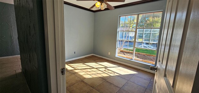 spare room with a wealth of natural light, tile patterned floors, crown molding, and ceiling fan