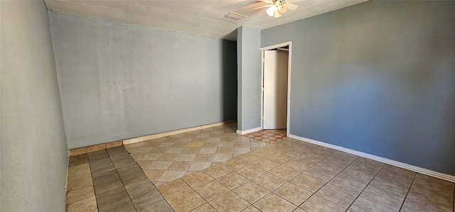 tiled spare room with ceiling fan