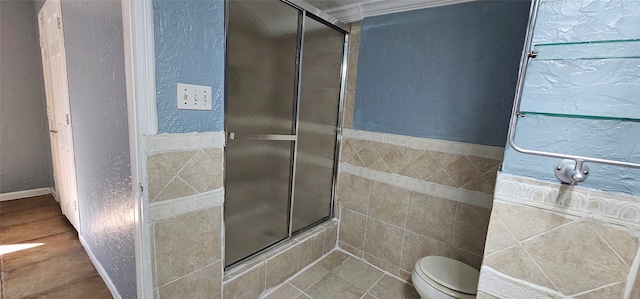 bathroom featuring tile patterned floors, toilet, and a shower with shower door