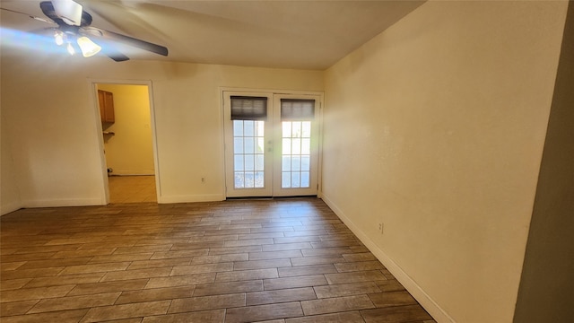 empty room with french doors, ceiling fan, and light hardwood / wood-style floors