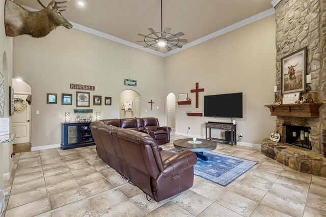 tiled living room featuring ornamental molding, ceiling fan, and a high ceiling