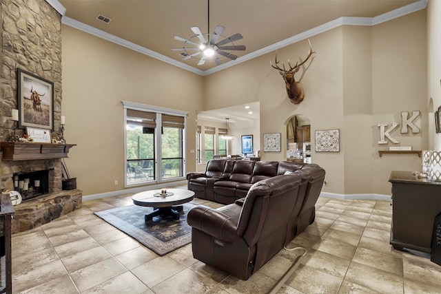 living room featuring a fireplace, crown molding, ceiling fan, and a towering ceiling