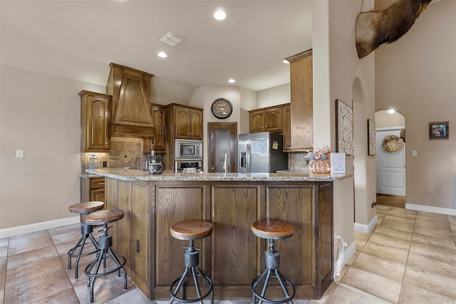 kitchen with appliances with stainless steel finishes, a breakfast bar area, and backsplash