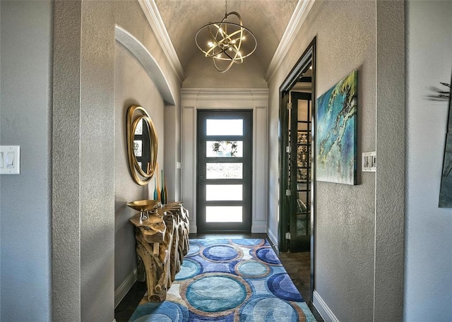 doorway to outside with crown molding, lofted ceiling, and an inviting chandelier