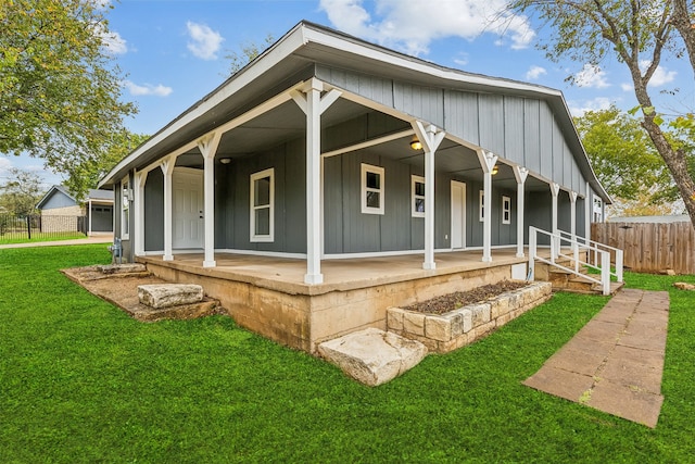 rear view of house with covered porch and a lawn