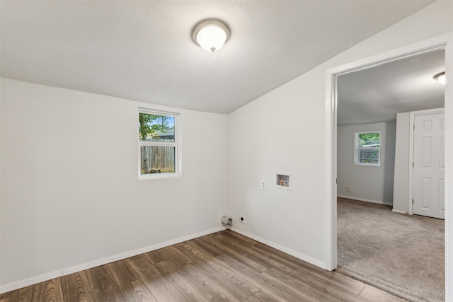 unfurnished room with a wealth of natural light, hardwood / wood-style floors, lofted ceiling, and a textured ceiling