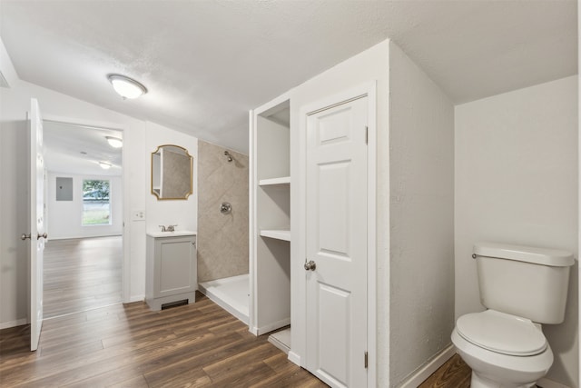 bathroom with wood-type flooring, walk in shower, a textured ceiling, vaulted ceiling, and toilet