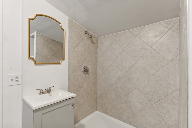 bathroom with vanity and a tile shower