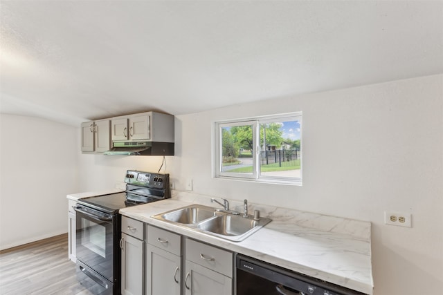 kitchen featuring light hardwood / wood-style floors, gray cabinetry, sink, and black appliances