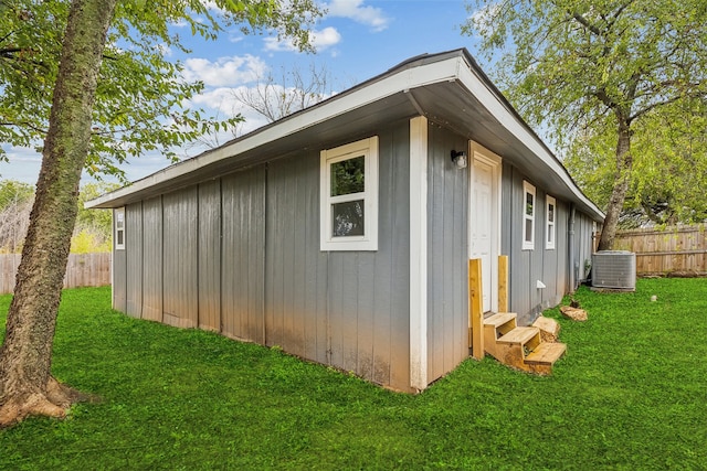 view of property exterior featuring a yard, an outdoor structure, and cooling unit