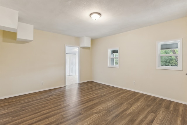 unfurnished room featuring dark hardwood / wood-style floors and a healthy amount of sunlight