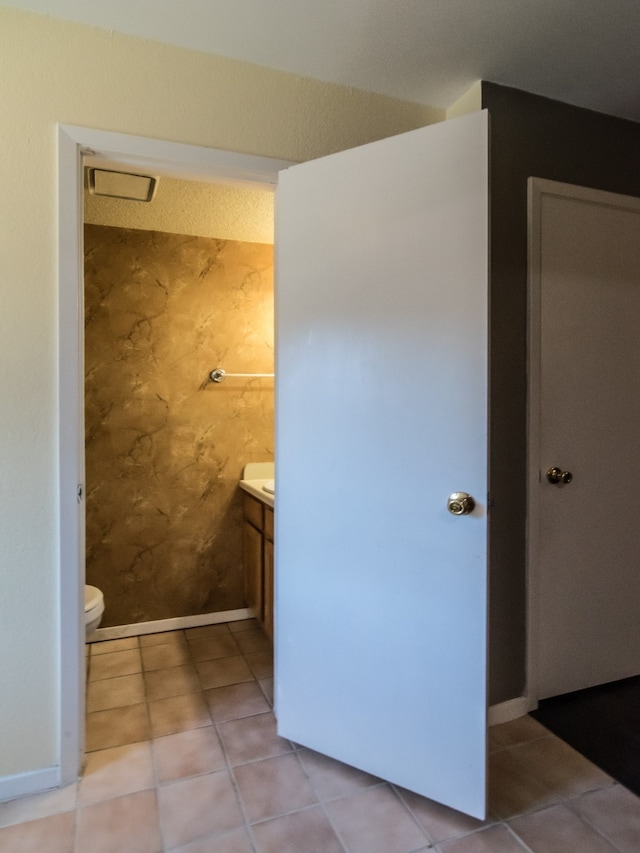 bathroom featuring vanity, tile patterned flooring, and toilet