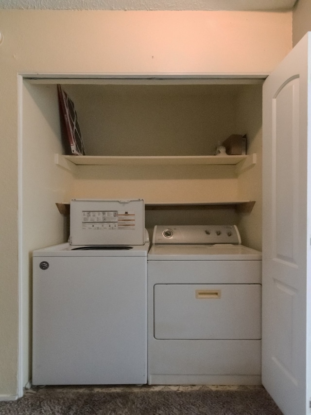 laundry room featuring separate washer and dryer and dark carpet